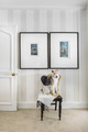 Coastal-inspired bedroom with the Brome Stripe in taupe wallpaper and a Fox Terrier dog adding a touch of warmth.